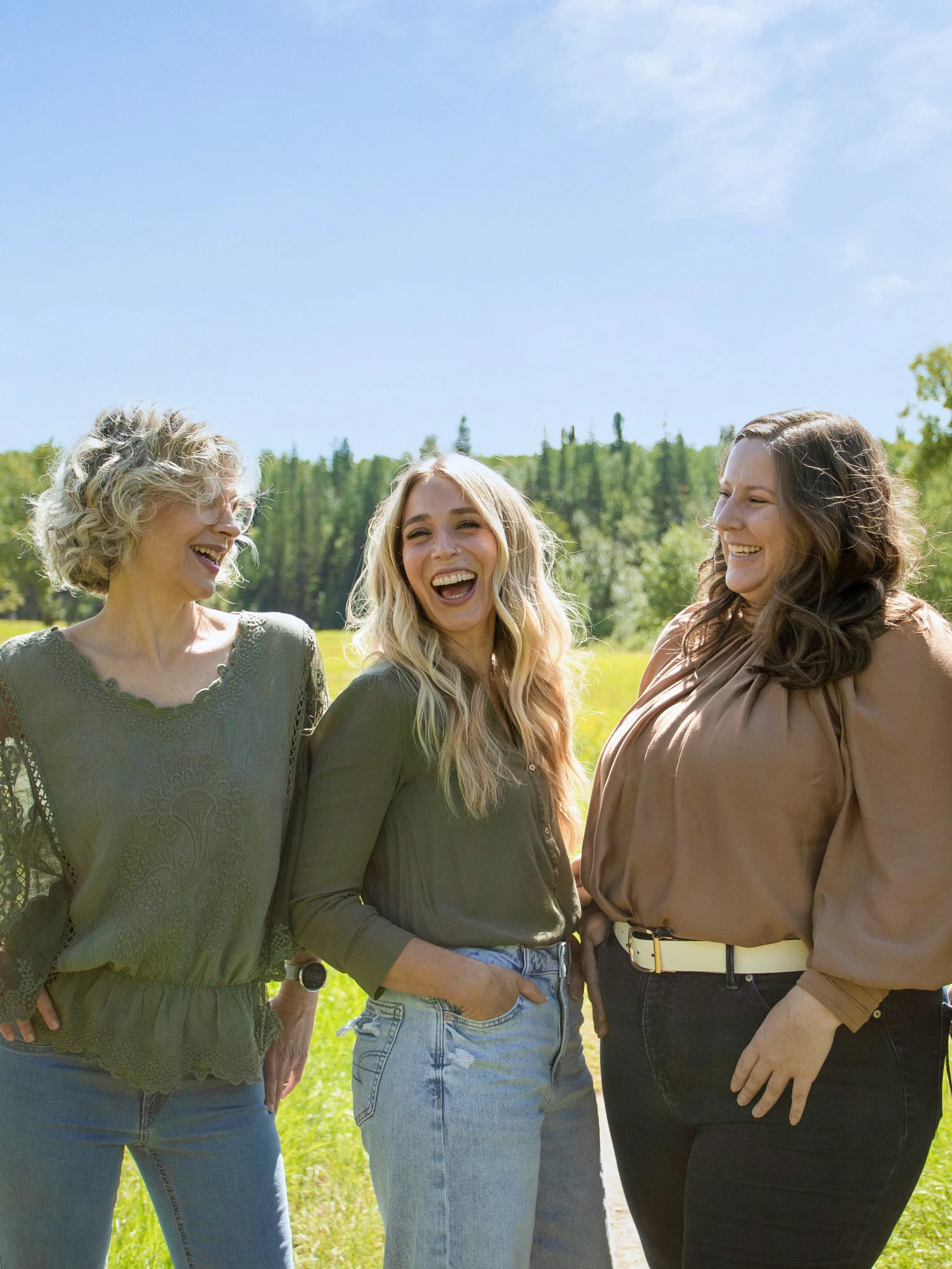 A photograph taken outdoors of three women who are looking at each other and smiling. The women are three members of the Valeo team: Maria Frais, Registered Psychologist, Alana Wolframe, Office Administrator, and Nichola Penny, Registered Provisional Psychologist